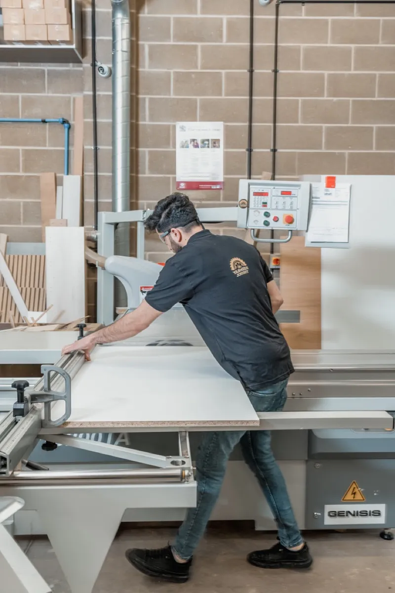 Craftsman operating a panel saw in the workshop