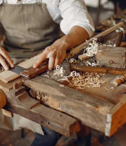 Yasmeen Joinery craftsman finishing a piece at the workbench
