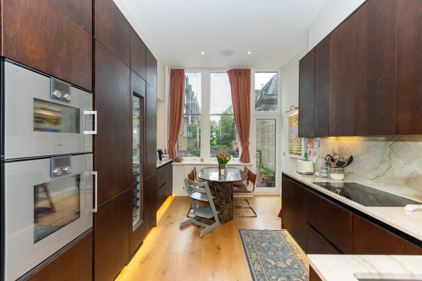 Galley view of oak kitchen with marble splashback — Phillimore Gardens, Kensington