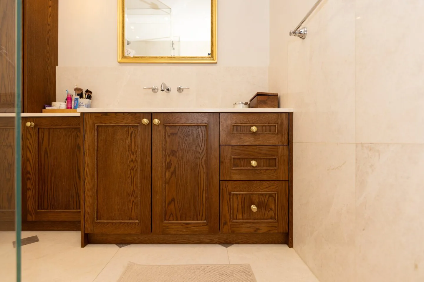 Detail of oak bathroom vanity cabinet with brushed brass knobs — Phillimore Gardens, Kensington