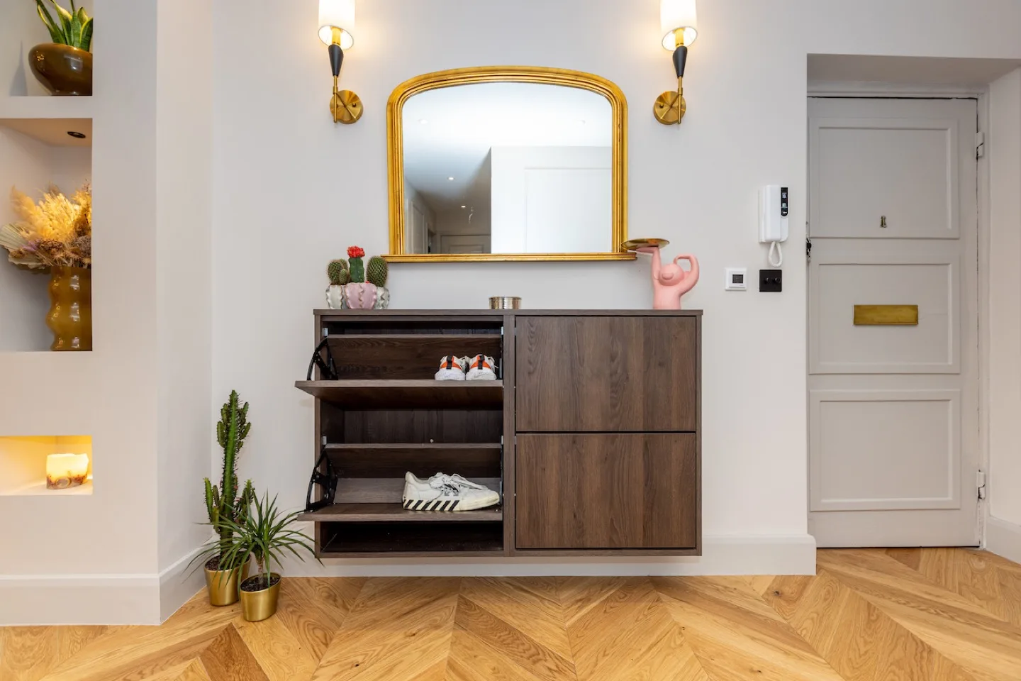 Dark oak shoe cabinet with its pull-down compartment open to reveal angled racks holding trainers
