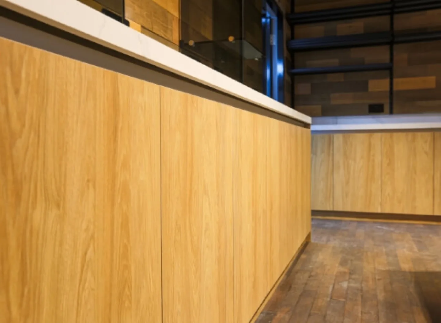 Oak-clad serving counter with white marble worktop and glass-topped display