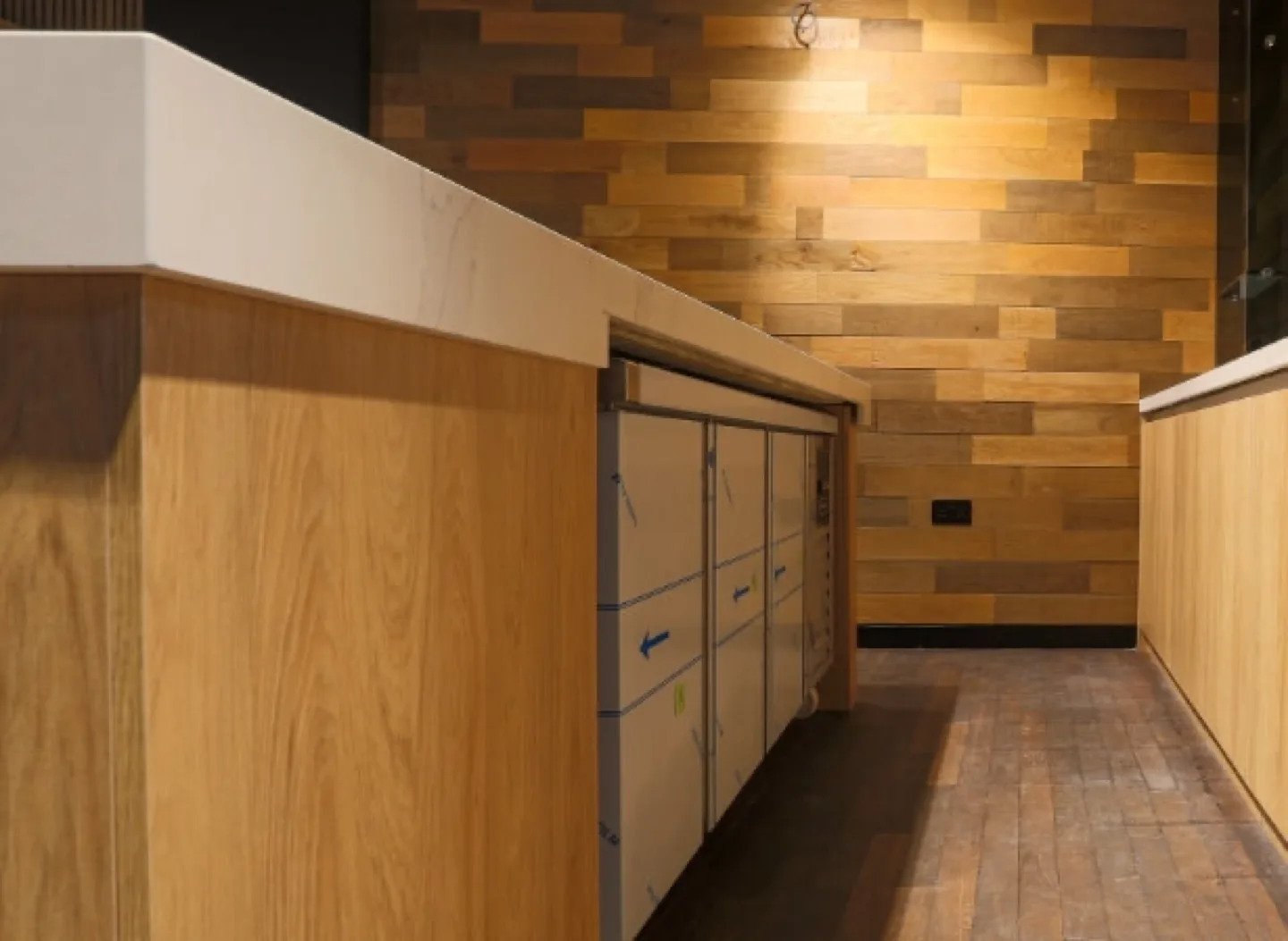 Marble-topped counter with concealed cupboards against oak-clad shop wall
