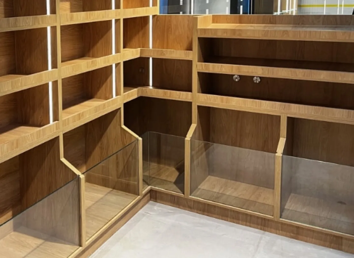 Bespoke oak bakery display unit with stepped shelving and glass partitions