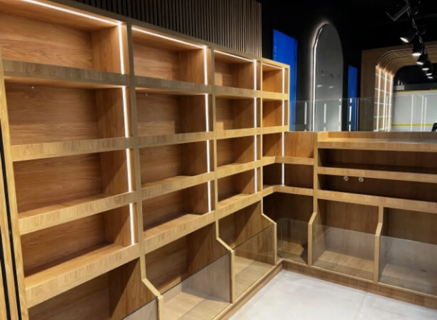 Corner oak shelving bays with LED strips and glass-fronted lower units