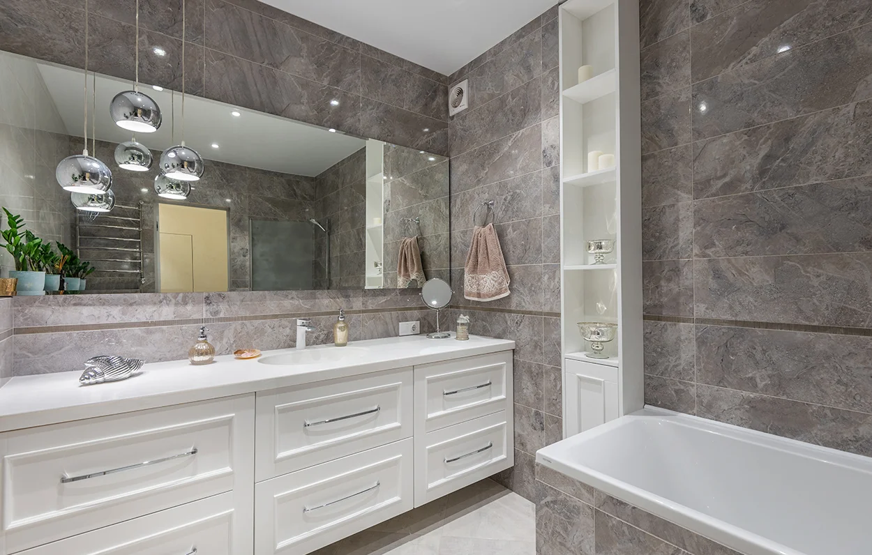 Bathroom with marble walls and fitted cabinets