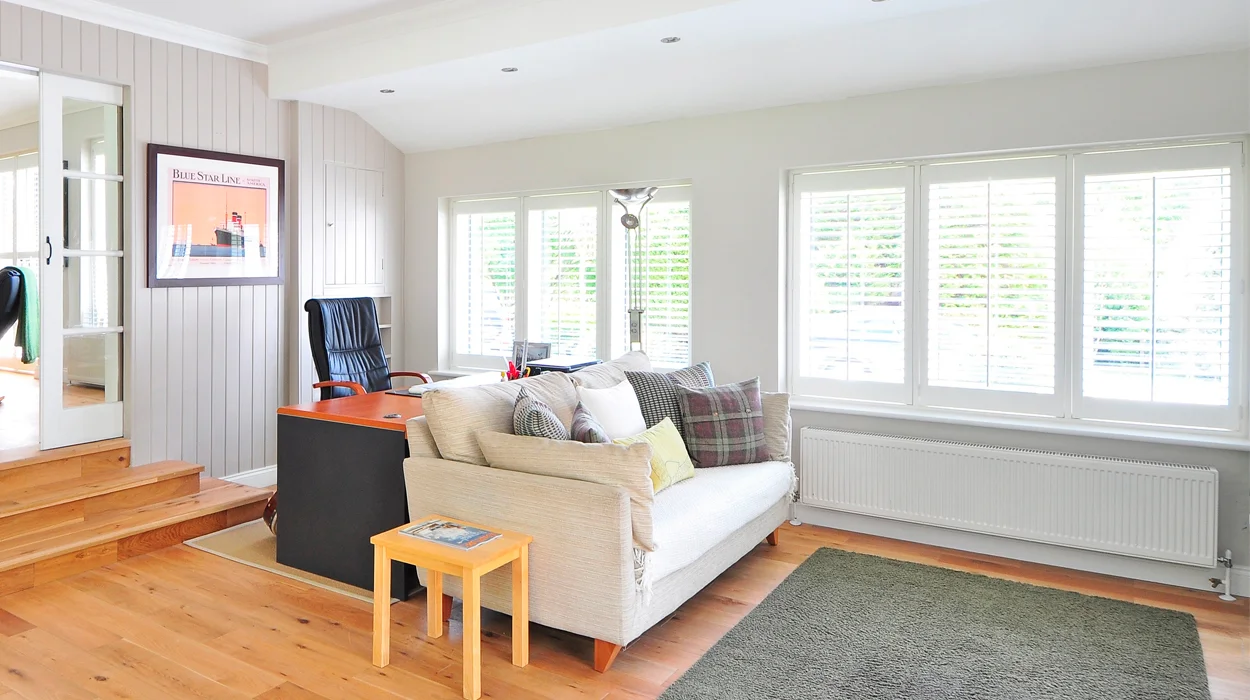 Bright living room with timber windows and a wooden desk