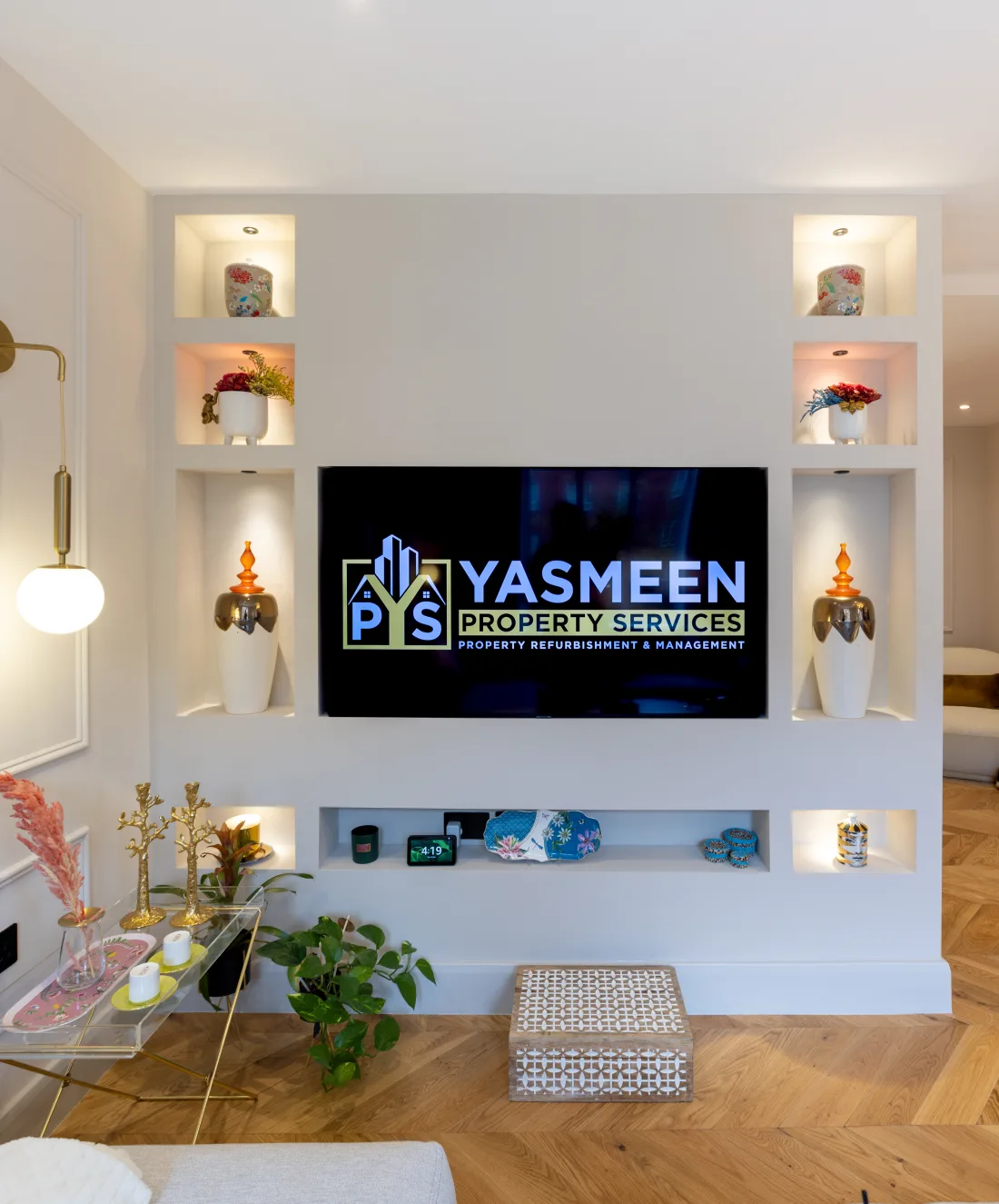 Bespoke media feature wall with lit display niches and a TV